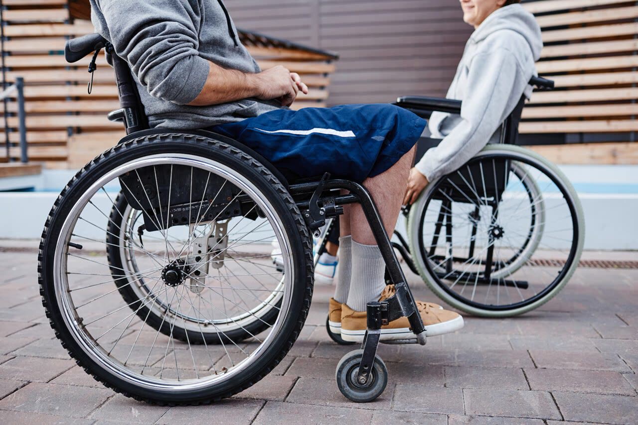 Friends who use wheelchairs enjoying time together outside
